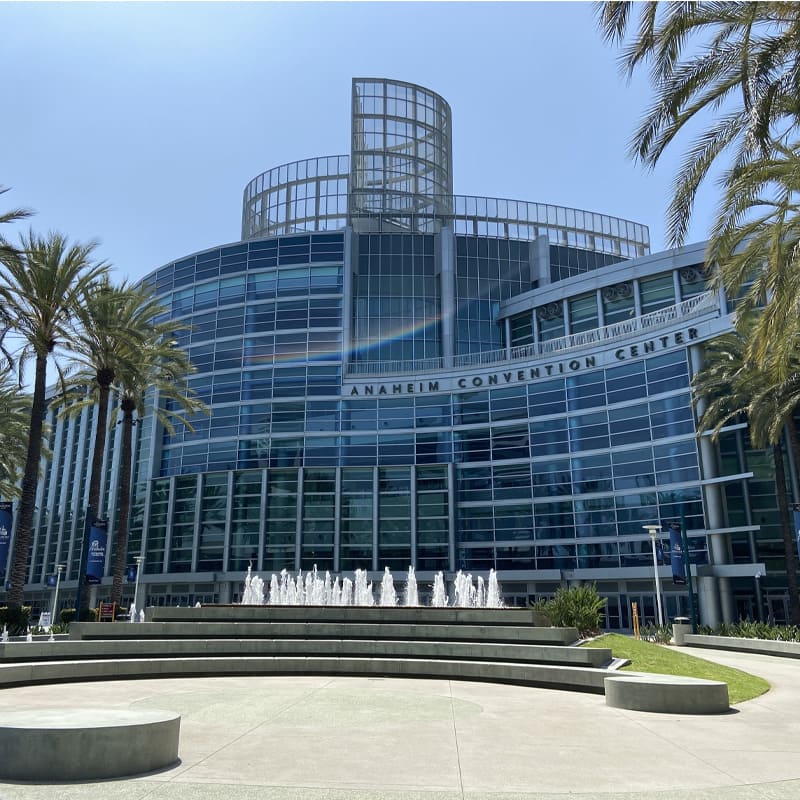 Anaheim Convention Center with fountains and palm trees on a clear day