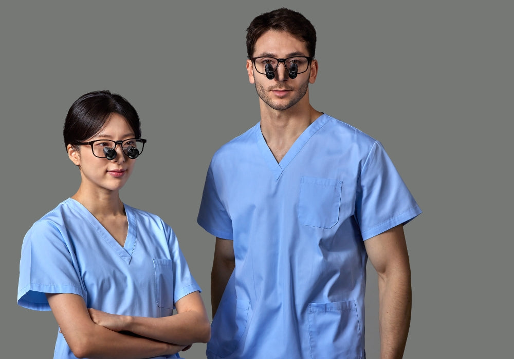 male and female in blue scrubs wearing illuco loupes