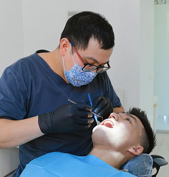 Dentist examining a patient's teeth in a dental office.
