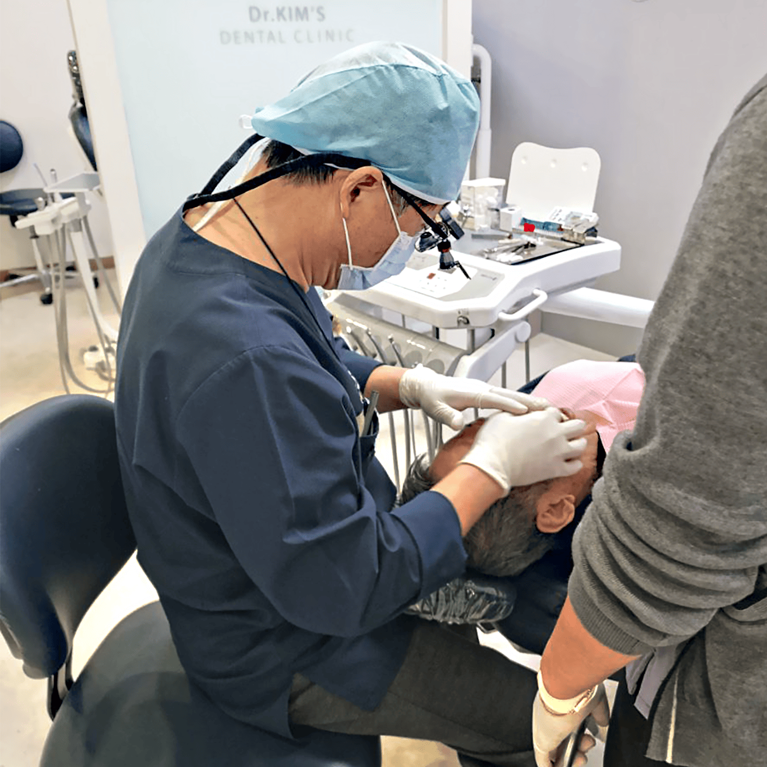 Dental procedure being performed in a clinic setting with dental tools and equipment visible.