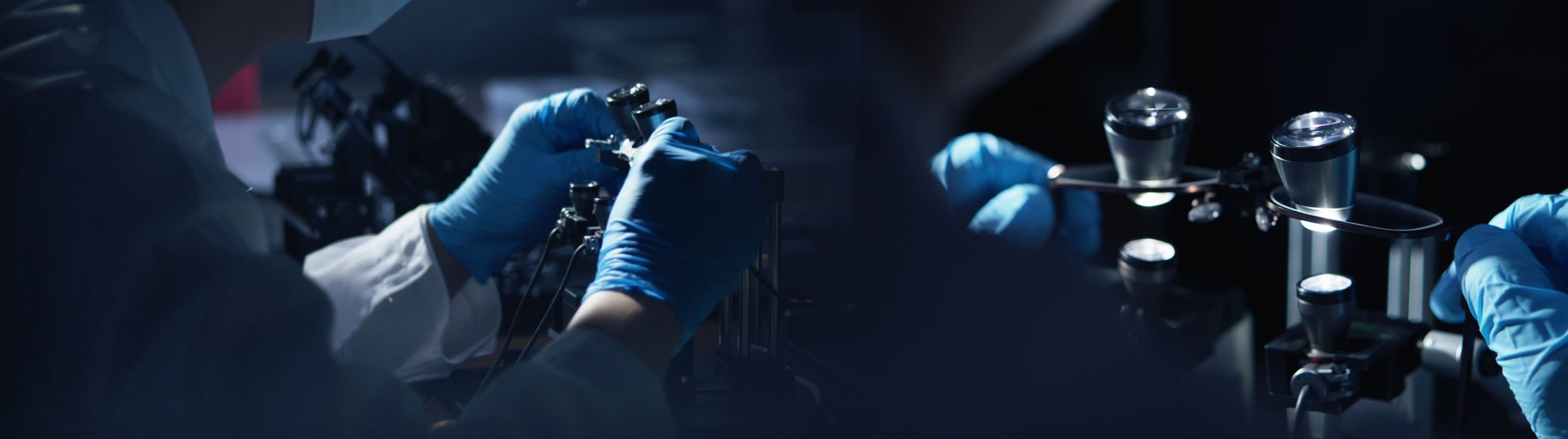 Person in a lab setting wearing gloves and handling equipment.