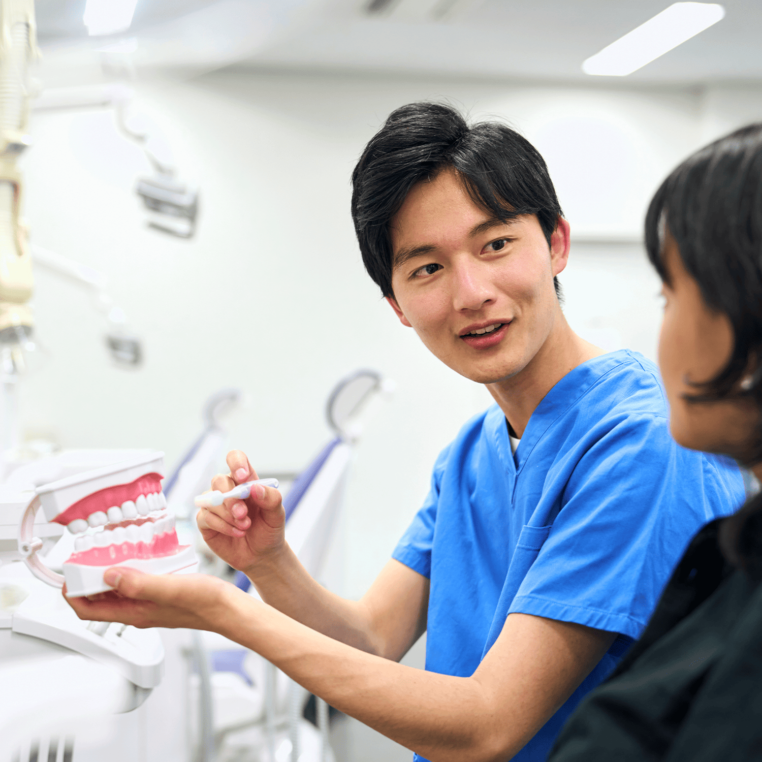 Dental student holding a dental model in a classroom setting